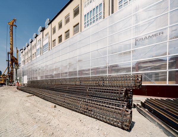 Schall- und Staubschutz auf breiter Front: Im Zuge des Neubaus eines Tiefgaragen- und Geschäftshauskomplexes nahe der Münchener Altstadt sorgt die Krämer Gerüstbau GmbH aus Bockhorn für Staub- und Schallschutz. Hierzu kommt das Scaffguard-System von Scafom-rux zum Einsatz, das an freistehenden Ringscaff-Gerüstkonstruktionen befestigt wurde. Clou bei der wandernden Baustelle ist die komplette Versetzbarkeit von bis zu 11 m breiten Schutz-Elementen inklusive Stützgerüst. geruest.com